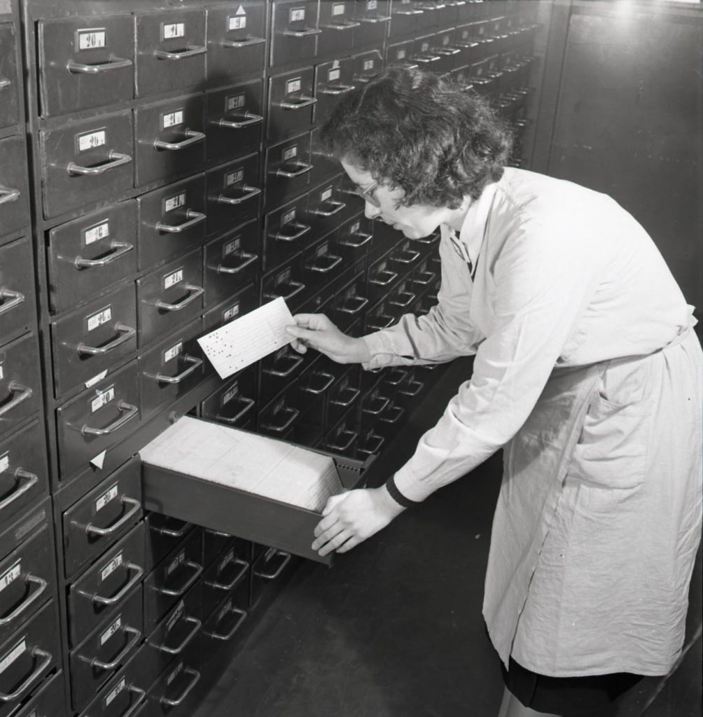 A BNCI employee checks client files in the Connais Domain Security Room, [1930 - 1950], rating 6Fi255-2